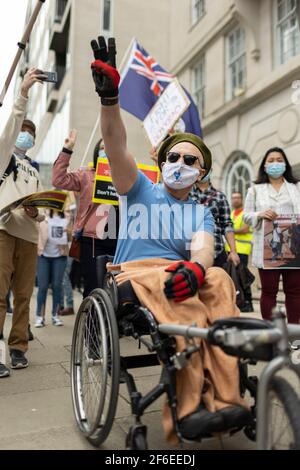 London, Großbritannien. März 2021, 31st. Ein behinderter Mann zeigt seine Unterstützung und macht den dreifingigen Gruß des Widerstands. Demonstranten versammelten sich auf dem Parliament Square - mit Gesichtsmasken und beobachteten eine soziale Distanzierung -, bevor sie zur chinesischen Botschaft marschierten, um Solidarität mit dem Volk von Myanmar gegen den Militärputsch und die staatlichen Tötungen von Zivilisten zu zeigen. Vor der Botschaft wurden Reden gehalten. Seit Beginn des Militärputsches am 1st. Februar wurden in Myanmar mehr als 520 Menschen von Sicherheitskräften getötet. Am vergangenen Samstag war der gewalttätigste Tag, an dem mehr als 100 Menschen getötet wurden. Kredit: Stockfoto