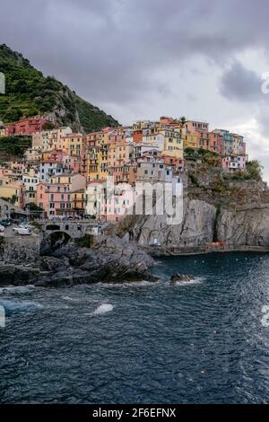 Klassische Ansicht von Manarola, Cinque Terre, Italien - Bunte Häuser in einer dramatischen Felsformation am Meer mit einem natürlichen Fischerhafen Stockfoto