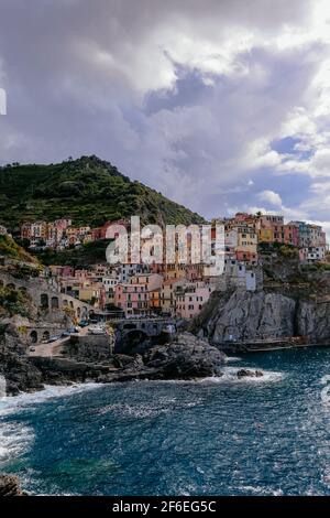 Klassische Ansicht von Manarola, Cinque Terre, Italien - Bunte Häuser in einer dramatischen Felsformation am Meer mit einem natürlichen Fischerhafen Stockfoto
