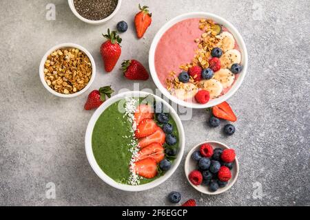 Matcha Grüner Tee Frühstück Superfoods Smoothies Schüssel mit Erdbeeren, Heidelbeeren, Kokosflocken obendrauf, Draufsicht, flach legen Stockfoto