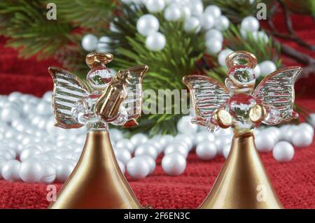 Zwei Engelsfiguren auf dem Hintergrund von künstlicher Tanne und Schnee. Weihnachtsdekoration und Ornamentik Konzept. Stockfoto
