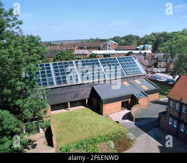 Eine Reihe von auf dem Dach montierten Sonnenkollektoren zum Erhitzen von Wasser für einen Swimmingpool im darunter liegenden Gebäude. Abbot's Bromley School, Staffordshire. Stockfoto