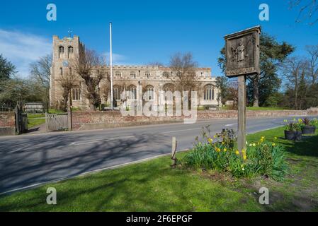Coggeshall Essex, Blick im Frühling auf die Pfarrkirche St. Peter Ad Vincula und das Dorfschild auf Church Green in Coggeshall, Essex, Großbritannien Stockfoto