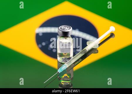 Impfkonzept mit reflektierter und entkoketer Flagge Brasiliens, selektiver Fokus auf Impfstoff Stockfoto
