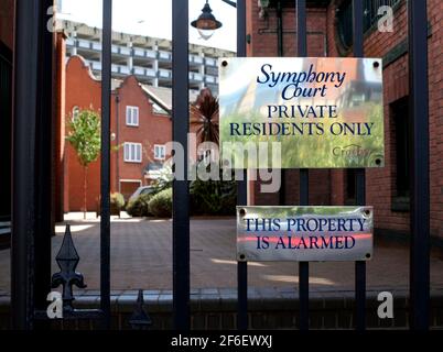 Hinweise auf einem eingezäunten Fußgängereingang zum Symphony Court, einem Wohnungssystem in der Nähe des Zentrums von Birmingham. Stockfoto