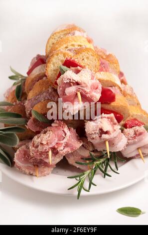 Rustikale rohe Spieße, fertig zum Kochen, mit truthahn, Wurst, Schweinefleisch, Gemüse, Kräuter und Brotscheiben auf weißem Hintergrund. Nahaufnahme. Stockfoto
