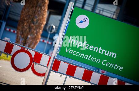 Hannover, Deutschland. März 2021, 31st. Ein Schild mit der Aufschrift "Impfzentrum" steht zwischen den Barrier-Leuchtfeuern auf dem Messegelände. Quelle: Moritz Frankenberg/dpa/Alamy Live News Stockfoto