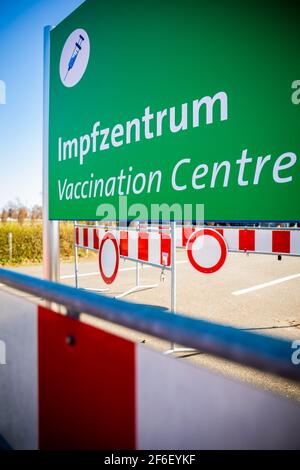 Hannover, Deutschland. März 2021, 31st. Ein Schild mit der Aufschrift "Impfzentrum" steht zwischen den Barrier-Leuchtfeuern auf dem Messegelände. Quelle: Moritz Frankenberg/dpa/Alamy Live News Stockfoto