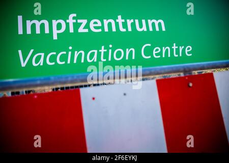 Hannover, Deutschland. März 2021, 31st. Ein Schild mit der Aufschrift "Impfzentrum" steht zwischen den Barrier-Leuchtfeuern auf dem Messegelände. Quelle: Moritz Frankenberg/dpa/Alamy Live News Stockfoto