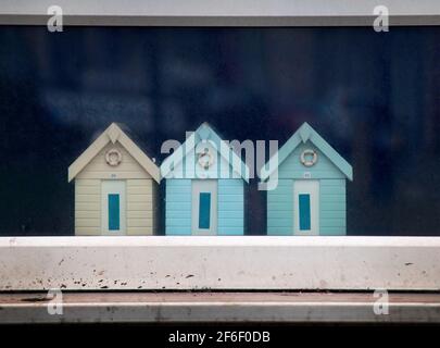 Kleine Strandhütten im Fenster eines Brighton-Hauses Stockfoto