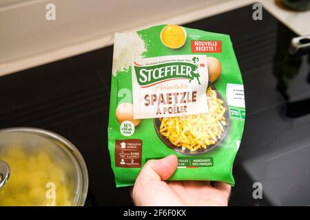 POV männliche Hand hält neues Paket von Stoeffler Spätzle In der Pfanne getrocknet werden Stockfoto