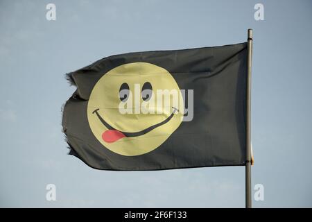 Ein Smiley Face House Music Flag. Happy Face Festival Symbol mit roter Zunge! Lecker, lecker. Stockfoto