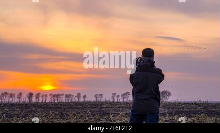 (210331) -- BAICHENG, 31. März 2021 (Xinhua) -- Pan Shengyu, Leiter des Zhenlai-Vogelschutzteams der China Wildlife Conservation Association, fotografiert Zugvögel im Bezirk Zhenlai, Stadt Baicheng, nordöstlich der Provinz Jilin, 30. März 2021. Eine Gruppe von Menschen gehen oft langsam und sprechen mit leiser Stimme am Rande des Feuchtgebiets im Bezirk Zhenlai, wenn das Wetter sich erwärmt. Manchmal nehmen sie ein Fernglas auf, um nach draußen zu schauen, und manchmal beugen sie ihren Kopf, um die geographischen Koordinaten auf ihren Mobiltelefonen aufzuzeichnen. Sie sind Mitglieder des Zhenlai Vogelschutzteams in China Stockfoto