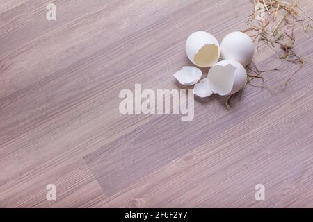 Schöne Hähnchen und Wachteln ostereier auf Holzhintergrund. Frohe ostern Korb Dekoration Szene. Traditionelle handgemachte Osternest Deko mit Stroh. Stockfoto