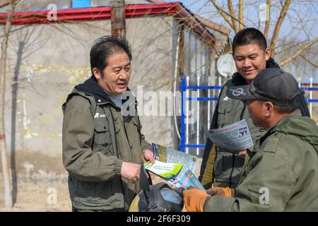 (210331) -- BAICHENG, 31. März 2021 (Xinhua) -- Mitglieder des Zhenlai-Vogelschutzteams der China Wildlife Conservation Association stellen einem Dorfbewohner im Bezirk Zhenlai, Stadt Baicheng, nordöstlich der Provinz Jilin, Wissen über Vogelschutz vor, 31. März 2021. Eine Gruppe von Menschen gehen oft langsam und sprechen mit leiser Stimme am Rande des Feuchtgebiets im Bezirk Zhenlai, wenn das Wetter sich erwärmt. Manchmal nehmen sie ein Fernglas auf, um nach draußen zu schauen, und manchmal beugen sie ihren Kopf, um die geographischen Koordinaten auf ihren Mobiltelefonen aufzuzeichnen. Sie sind Mitglieder von Zhenlai Vogel bewachen Tee Stockfoto