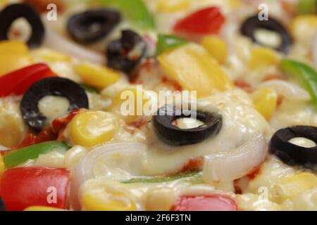 Pizza Farmers Pizza, hergestellt aus rotem, grünem und gelbem Paprika, Zwiebeln, schwarzen Oliven, Kegel und Mozzarella-Käse, dünne Gebäckkruste auf einem schwarzen gelegt Stockfoto