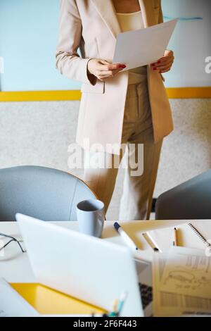Nahaufnahme einer vielbeschäftigten Frau, die an ihrem Arbeitsplatz steht Stockfoto