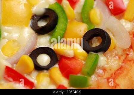 Pizza Farmers Pizza, hergestellt aus rotem, grünem und gelbem Paprika, Zwiebeln, schwarzen Oliven, Kegel und Mozzarella-Käse, dünne Gebäckkruste auf einem schwarzen gelegt Stockfoto