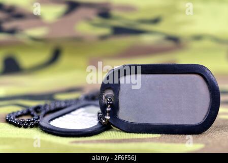 Militärische Hundeanhänger auf Camouflage-Stoff. Stockfoto