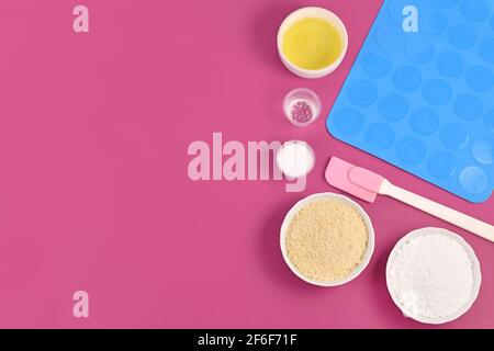 Zutaten für die Herstellung von hausgemachten französischen Macaron-Süßigkeiten, darunter Puderzucker, gemahlene Mandeln, Eiweiß, Salz und Backwerkzeuge Stockfoto