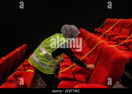 Pekanbaru, Riau, Indonesien. März 2021, 31st. Mitarbeiter desinfizieren Einrichtungen im Cinepolis-Kino Pekanbaru, Provinz Riau, Indonesien. Pekanbaru Kino wiedereröffnet, nachdem sie für ein Jahr geschlossen. Quelle: Afrianto Silalahi/ZUMA Wire/Alamy Live News Stockfoto