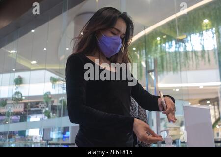 Pekanbaru, Riau, Indonesien. März 2021, 31st. Eine Frau wäscht ihre Hände mit einem Händedesinfektionsmittel, bevor sie das Cinepolis-Kino in Pekanbaru, Indonesien, betritt. Pekanbaru Kino wiedereröffnet, nachdem sie für ein Jahr geschlossen. Quelle: Afrianto Silalahi/ZUMA Wire/Alamy Live News Stockfoto