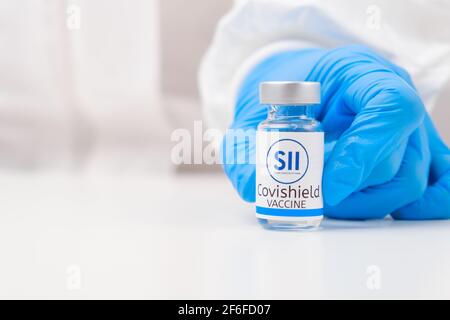 Covishield-Impfstoff gegen SARS-Cov-2, Coronavirus oder Covid-19, der vom Arzt in den Gummihandschuhen auf den Tisch gelegt wird. Stockfoto