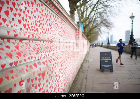 London, Großbritannien. 31. März 2021. Die Menschen gehen an der COVID-19 Memorial Wall am Embankment im Zentrum von London vorbei, die mit Herzen bemalt wurde, um an die mehr als 145.000 Menschen zu erinnern, die in Großbritannien an dem Coronavirus gestorben sind. Bilddatum: Mittwoch, 31. März 2021. Bildnachweis sollte lauten: Matt Crossick/Empics/Alamy Live News Stockfoto