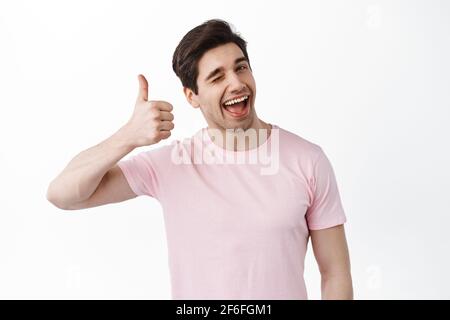 Sehr gutes Bro. Lächelnder winkender Mann zeigt Daumen nach oben in Zustimmung, mag und unterstützt Ihre Wahl, lobt großartige Arbeit, ausgezeichnete Arbeit, zufrieden zu stehen Stockfoto