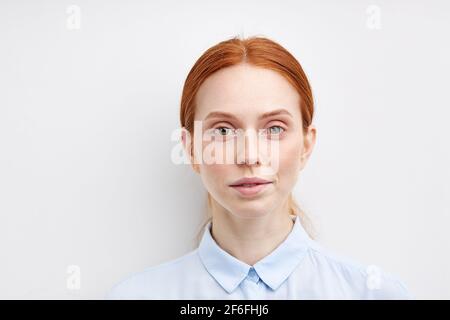 Junge Ruhige Frau Isoliert Auf Weißem Studio Hintergrund Modell Frau Mit Haar Gezogen Zurück, In Blau Formale Shirt. Nahaufnahme Porträt. Ruhige Menschliche Emotion, Fa Stockfoto