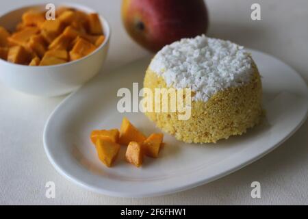 Gedämpfter gemahlener Reis, geschichtet mit Kokosraspeln und Mango. Lokal bekannt als Mango Puttu. Ein traditionelles gesundes Frühstücksgericht von Kerala. Schuss auf WH Stockfoto