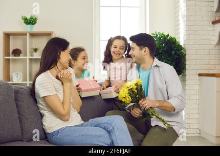 Liebevoller Mann mit Zwillingstöchtern gratuliert seiner Mutter zum Muttertag oder Geburtstag. Stockfoto