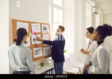 Eine Gruppe gemischter Büromitarbeiter steht und diskutiert Marketingentwicklungsstrategie Stockfoto