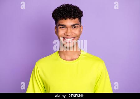 Foto von jungen gut aussehenden glücklich positive fröhlich afrikanischen Mann mit Welliges kurzes Haar auf violettem Hintergrund isoliert Stockfoto