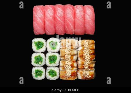 Sushi-Rollen-Set mit Lachs, Aal, japanischer Mayonnaise, Unagi-Sauce, Sesamsamen, chuka, Thunfisch-Nigiri. Isoliert auf schwarzem Hintergrund Stockfoto