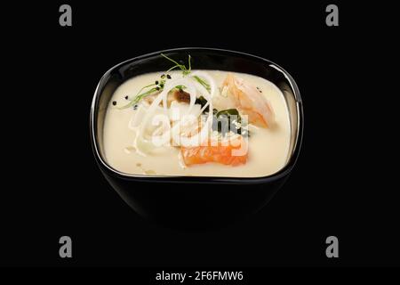 Thailändische Suppe mit Meeresfrüchten, Lachs, Garnelen, Muscheln, Gondashi, Shiitake-Pilze, Togarashi-Pfeffer, Lauch, Sesam. Thailändische Küche. Isoliert ein Stockfoto