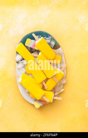 Fruchtige Fruchtknöchel. Vegan verschiedene bunte Eislollies auf einem Teller. Draufsicht, Leerraum Stockfoto