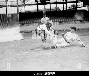 Der Baseballspielerin Ardis Yelton wird von Clyde Milan, Washington Senators, 10. Juni 1920, der richtige Weg gezeigt, um in eine Basis zu rutschen. Stockfoto