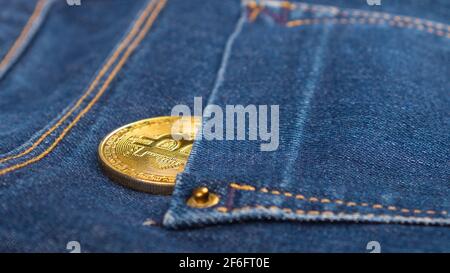 bitcoin-Münze in Jeans-Tasche, digitale Währung für Internet-Banking und internationale Netzzahlungen. Stockfoto