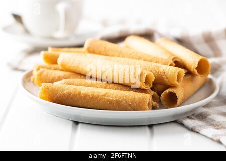 Süße Waffeltuben Rollen auf Teller auf weißem Tisch. Stockfoto