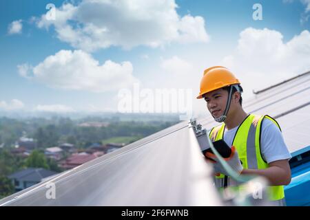 Asiatischer Ingenieur, der an der Überprüfung von Anlagen in Solarkraftwerken, Solarenergie, arbeitet Stockfoto