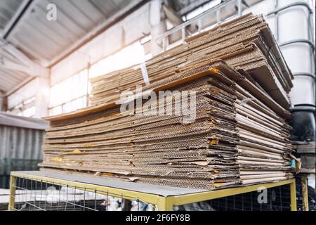 Stapeln Sie einen vorbereiteten Stapel aus gebrauchter komprimierter Wellpappe und Altpapierverpackung, der für das Recycling und die Wiederverwendung im Industriezentrum gesammelt wurde. Recycelbar Stockfoto