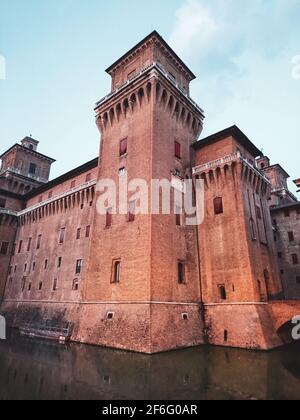 Eckturm des Castello Estense di Ferrara (Schloss Este) oder castello di San Michele (St. Michaels Burg) eine mittelalterliche, mit roten Ziegelsteinen bemalten Burg auf Wate Stockfoto