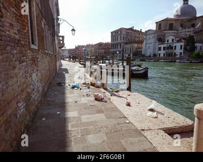 Straße mit Booten auf Kanal in Venedig, Italien. Möwe mit Müll, alte verwitterte Gebäudefassaden - Probleme der touristischen berühmten italienischen Stadt Stockfoto