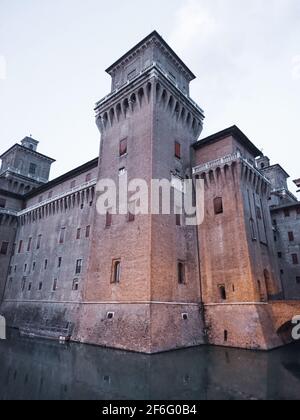 Eckturm des Castello Estense di Ferrara (Schloss Este) oder castello di San Michele (St. Michaels Burg) eine mittelalterliche, mit roten Ziegelsteinen bemalten Burg auf Wate Stockfoto