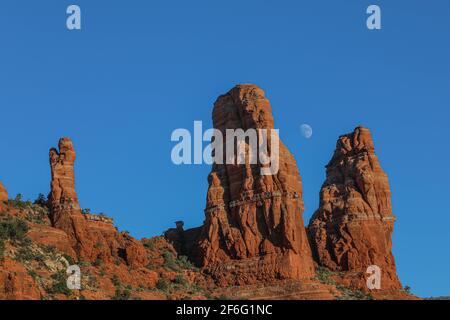 Der Mond steigt über den roten Felsen von Sedona Arizona gegen einen wunderschönen blauen Himmel. Stockfoto