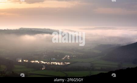 Aberystwyth, Ceredigion, Wales, Großbritannien. 31st März 2021 UK Wetter: Nach einem warmen sonnigen Tag steigt der Meeresnebel von der Küste von Aberystwyth auf und breitet sich in das Rheidol-Tal aus, während die Sonne hinter einer tief liegenden Wolke untergeht. © Ian Jones/Alamy Live News Stockfoto