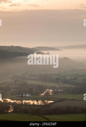 Aberystwyth, Ceredigion, Wales, Großbritannien. 31st März 2021 UK Wetter: Nach einem warmen sonnigen Tag steigt der Meeresnebel von der Küste von Aberystwyth auf und breitet sich in das Rheidol-Tal aus, während die Sonne hinter einer tief liegenden Wolke untergeht. © Ian Jones/Alamy Live News Stockfoto