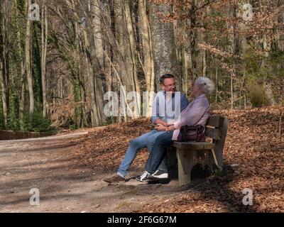 Ältere Mutter und ihr Sohn sitzen im Park Stockfoto
