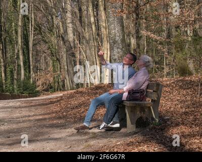 Ältere Mutter und ihr Sohn sitzen im Park Stockfoto